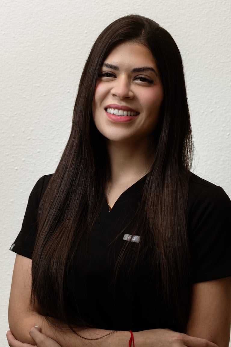 Professional portrait of a smiling woman with long dark hair wearing a black v-neck shirt against a white background